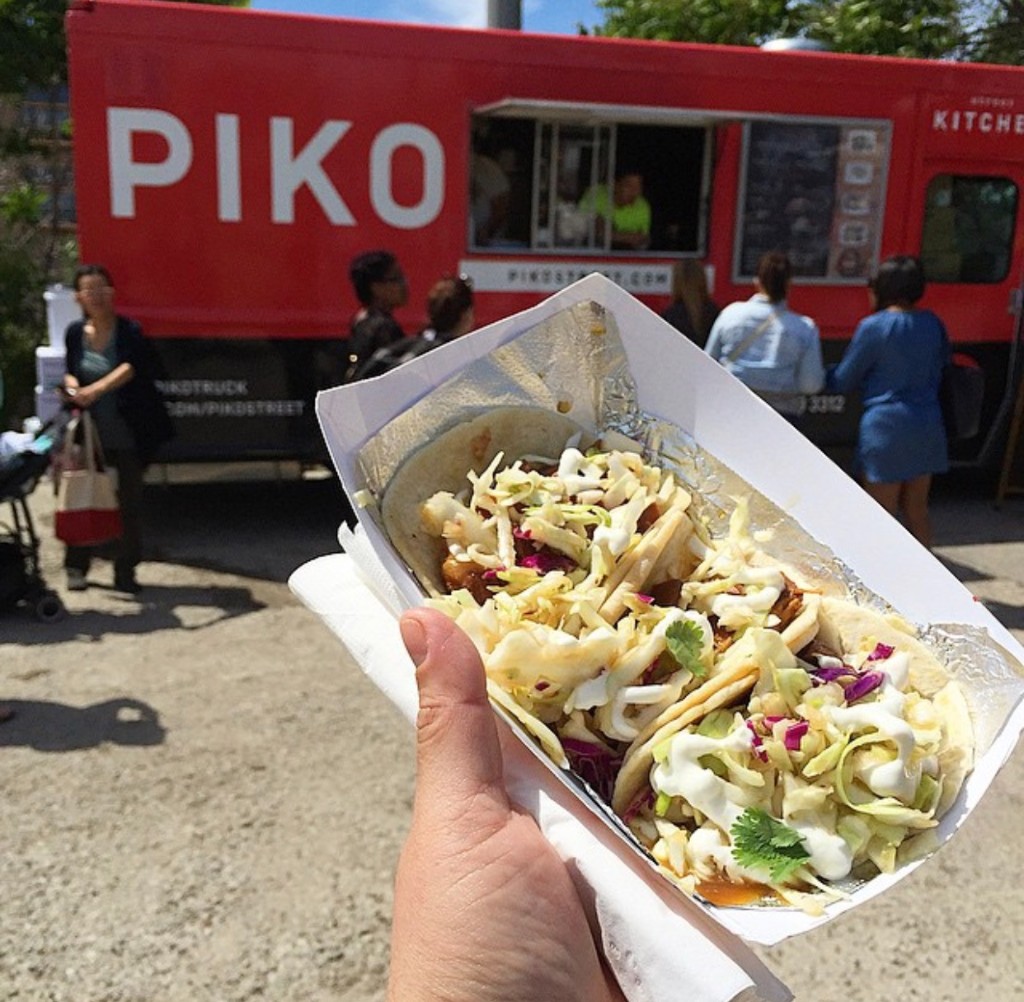 Two guests with drinks beside the Cupcakes for a Cure food truck on festival day