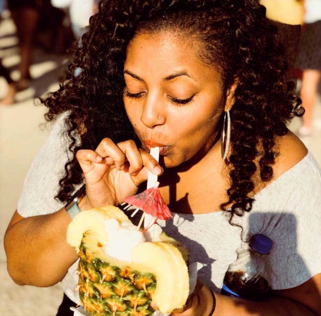 Guest sitting on the lawn eating mac and cheese from a Conewich cone on a sunny festival day