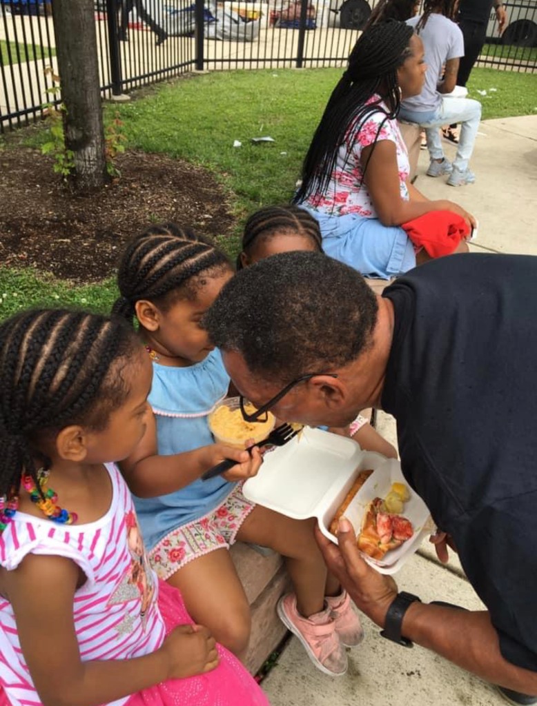 Individual deep-dish pizza in a box with a cup of beer on a weathered picnic table