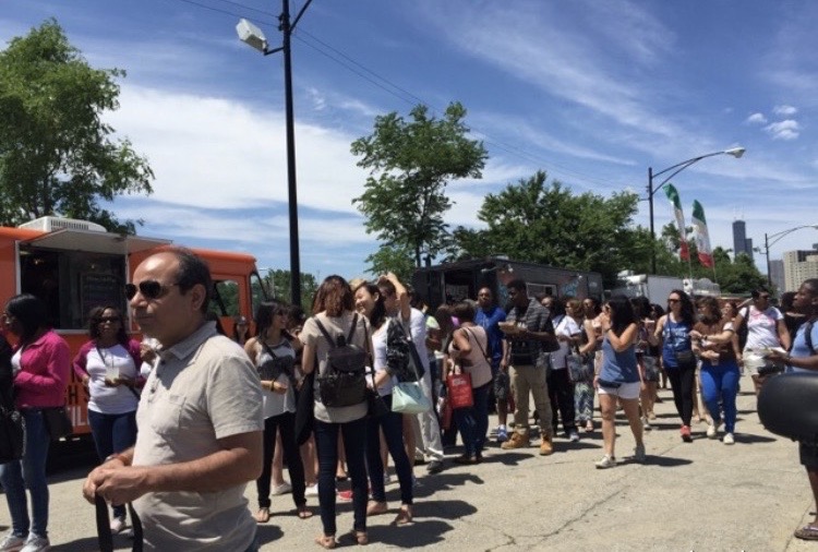 Afternoon light on the paved festival route with booths and food trucks