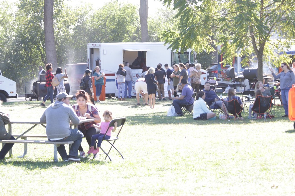 Colorful vendor row with trees behind the festival at Labagh Woods.