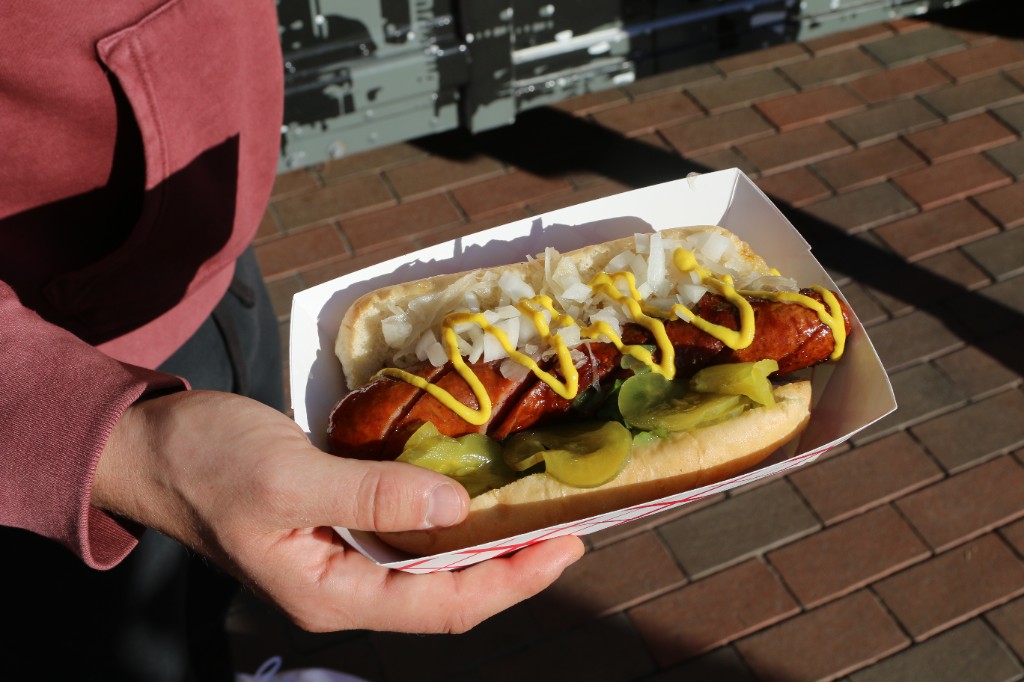 Loaded grilled sausage in a bun at a Wrigley Field food truck activation