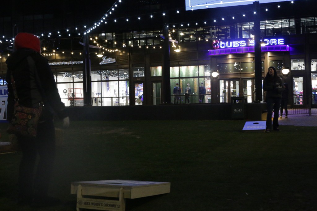 Guests in beanies beside the red Fat Shallot truck and lit menu board after dark