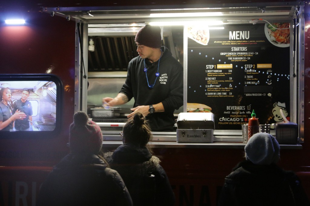 Silhouettes of guests watching live music on an outdoor stage at The Park at Wrigley