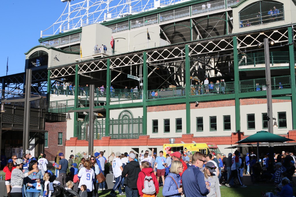 Cubs fans and food trucks along the walkway outside Wrigley Field