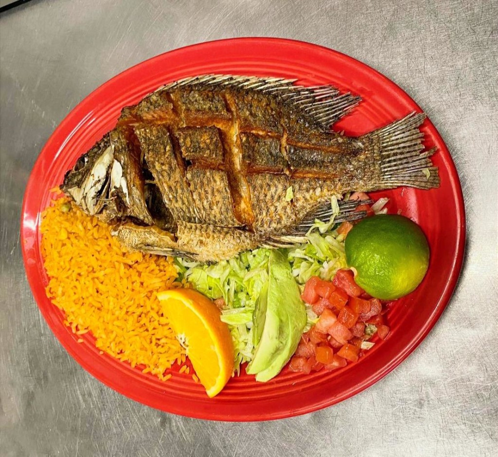 El Azteca — whole golden fried fish with seasoned rice, fresh avocado and tomato salad, and lime